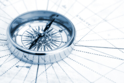 A compass sits on a navigational map